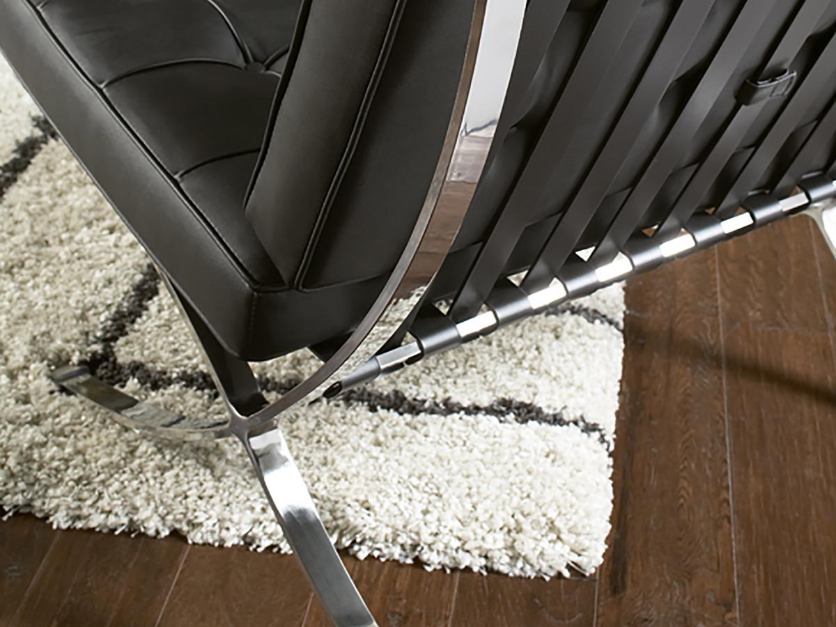 Close-up side view of Marco Chair showing metal frame and black leather upholstery