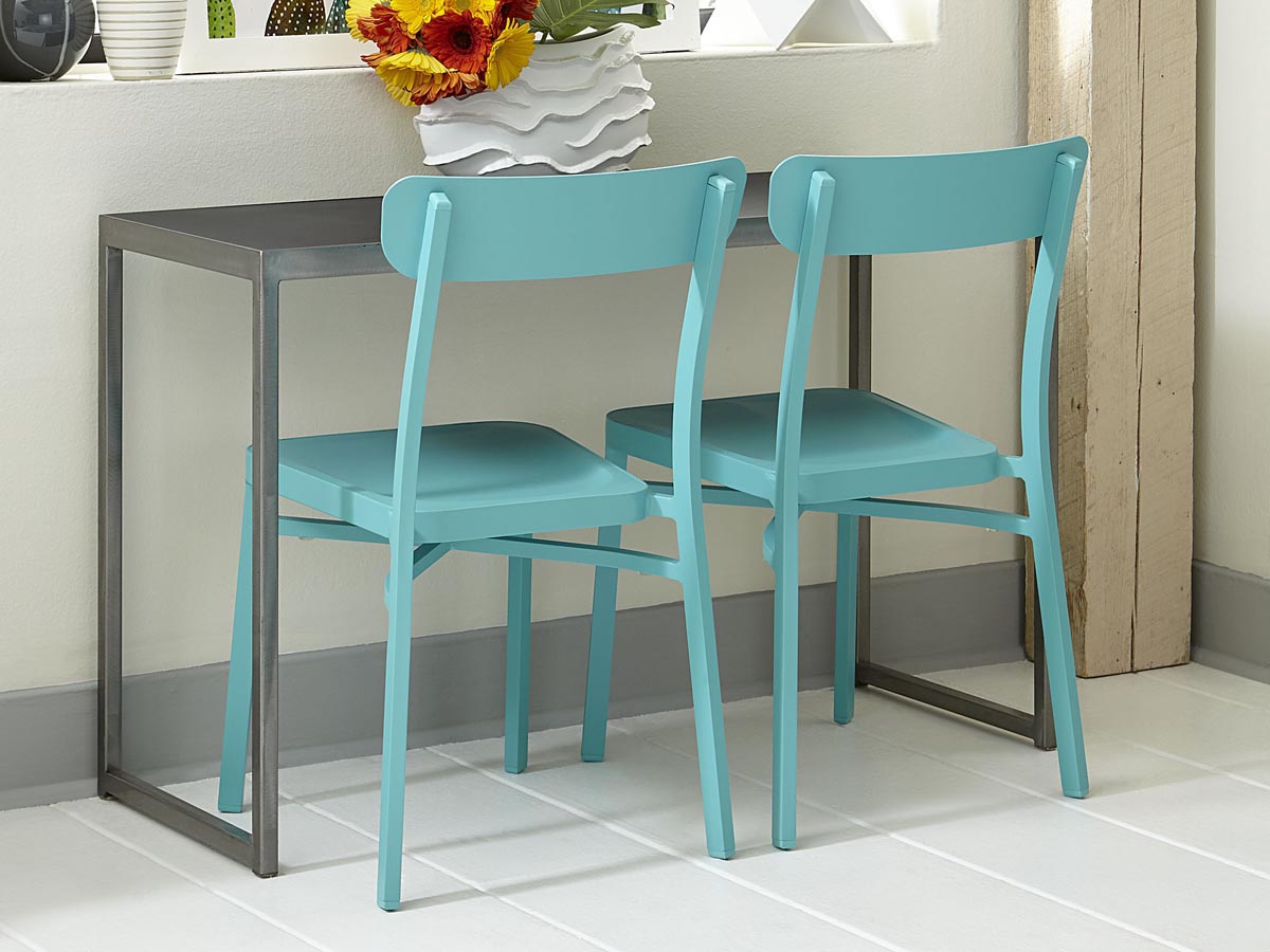 Teal dining chairs around a metal table in a kitchen